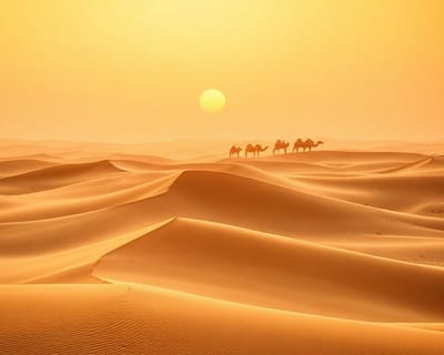 Wüstenlandschaft mit Kamelkarawane bei Sonnenaufgang